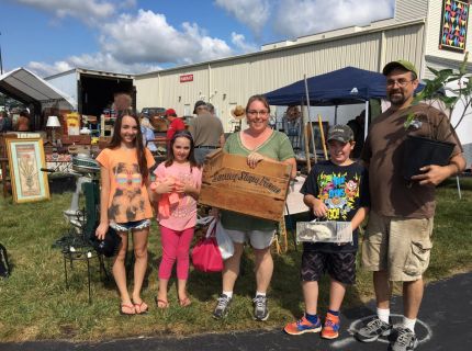 Family showing off their bought items from the 2017 Shipshewana Antique Festival
