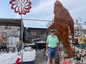 shopper posing with yeti metal art at shipshewana flea market